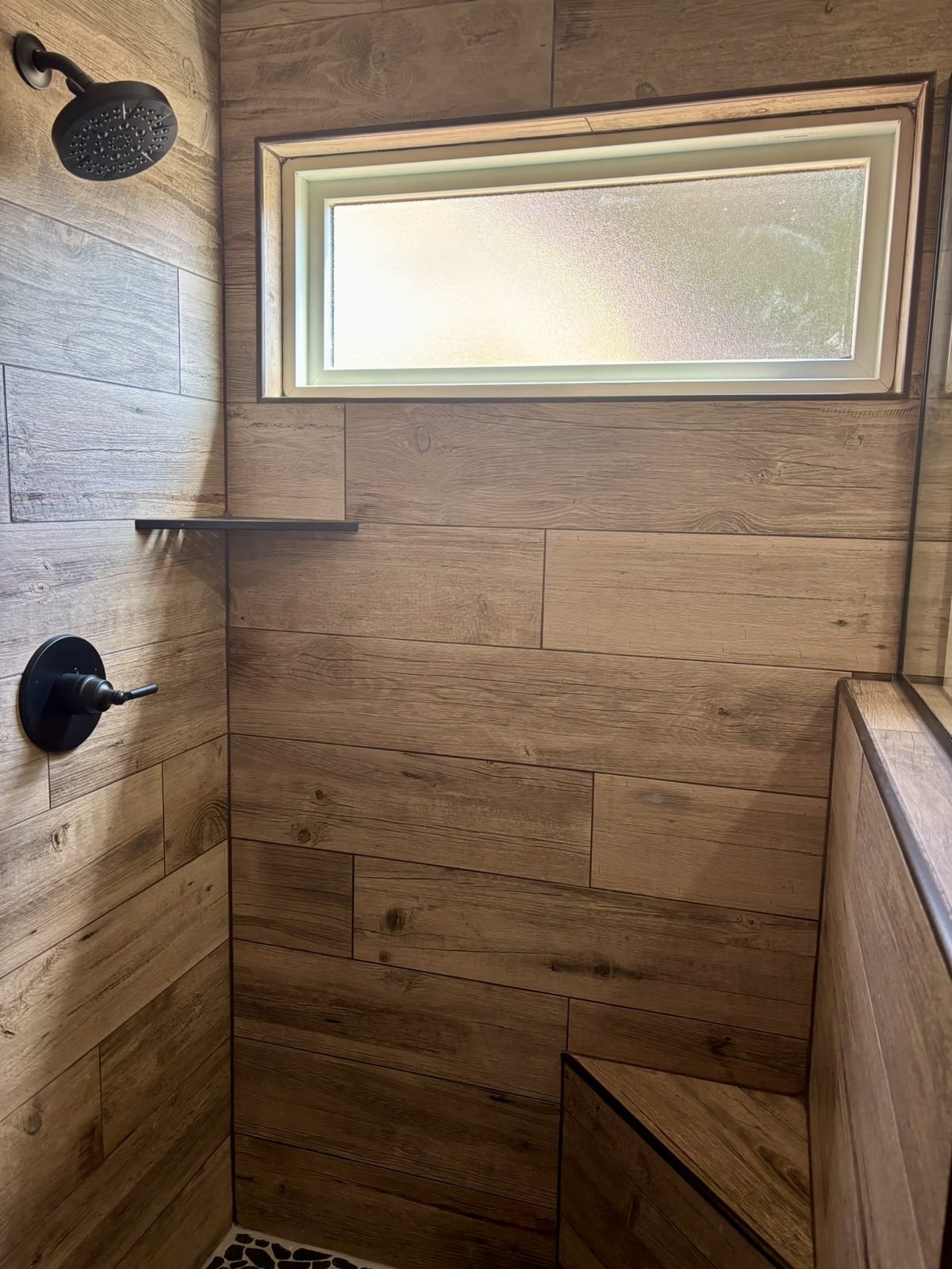 A closer view of the shower fittings and pebble floor