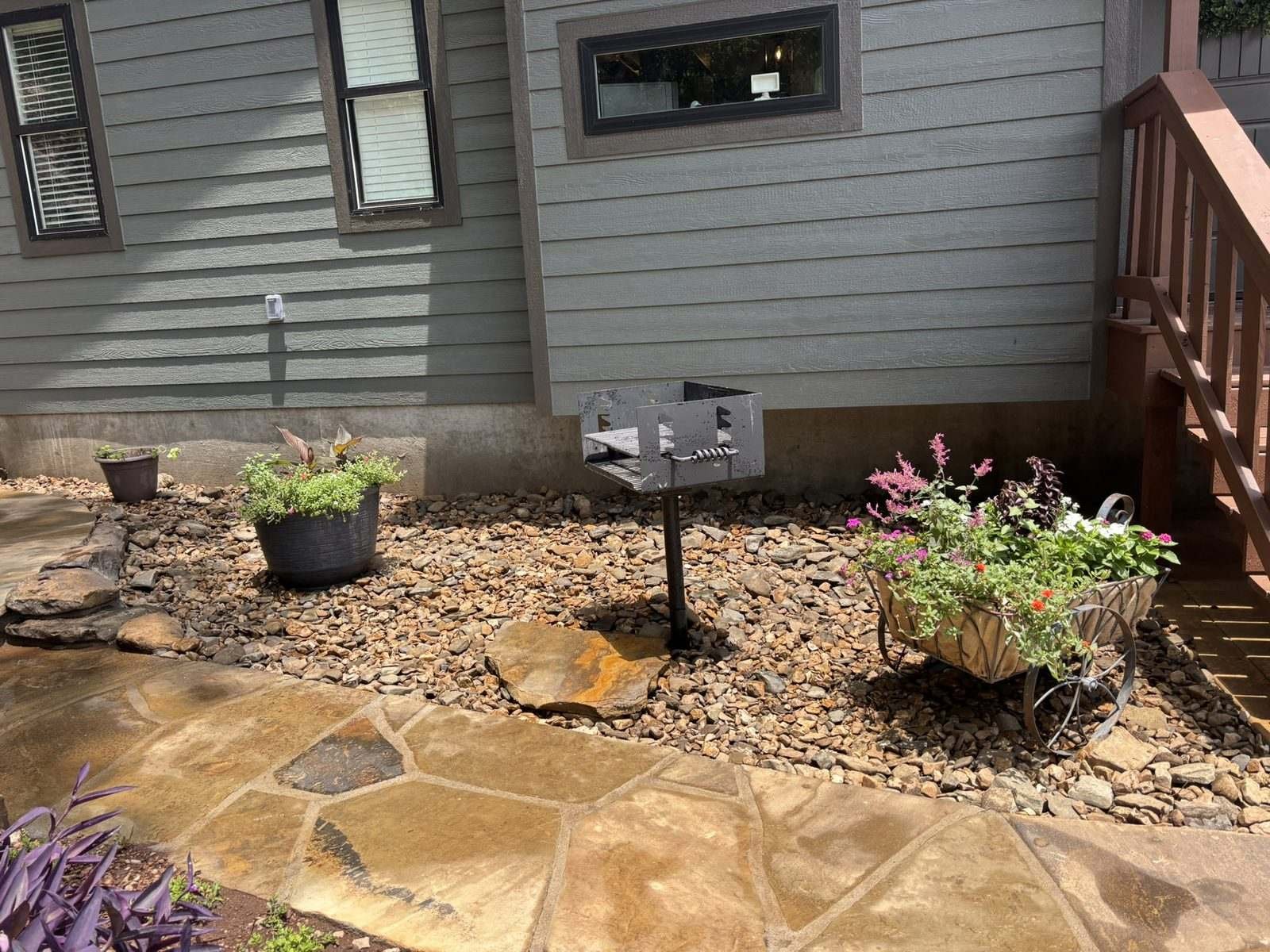A park-style charcoal grill on the flagstone terrace